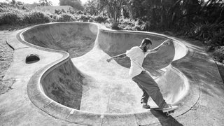 A skateboarder grinding the coping of a pool.