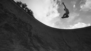 A skateboard getting air above a pool.