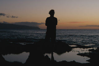 Arto Saari standing on a reef looking out to sea.