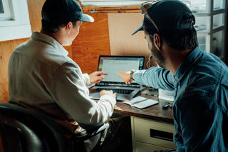 Two people designing a surfboard with a CAD program. 